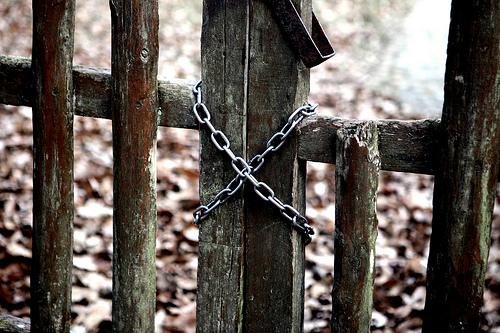 Une barrière en bois fermée par une chaîne